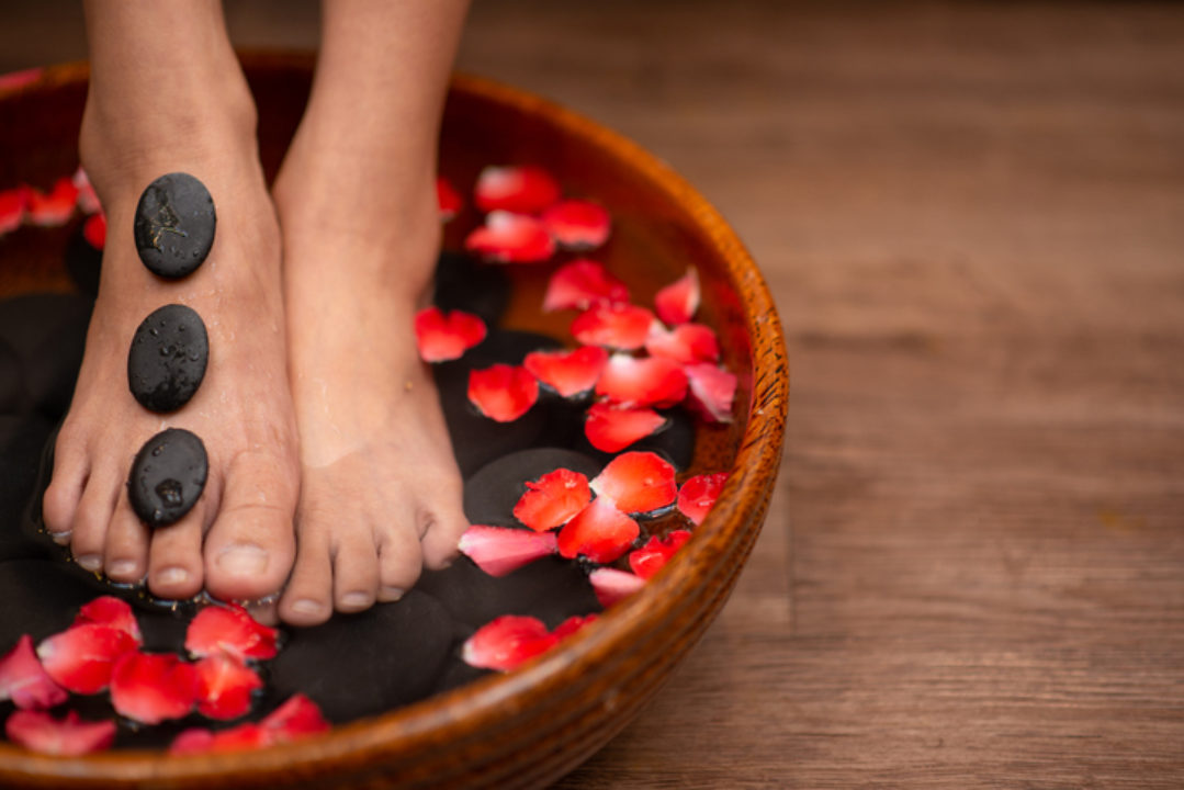 Beautiful female feet at spa soaking for foot care