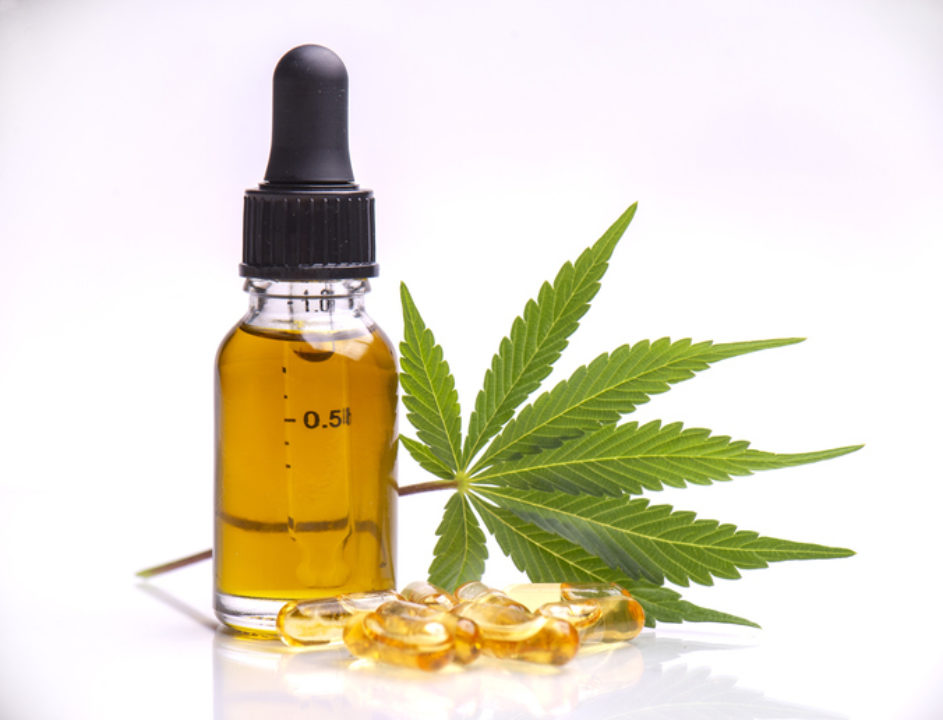A marijuana leaf and CBD oil and capsules