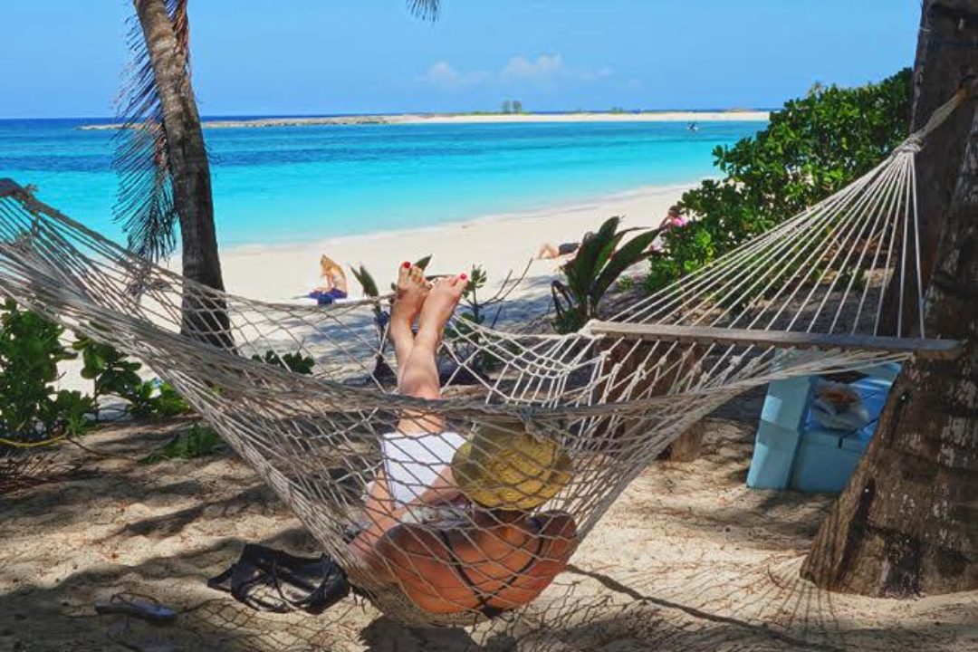 woman relaxing in hammock on beach
