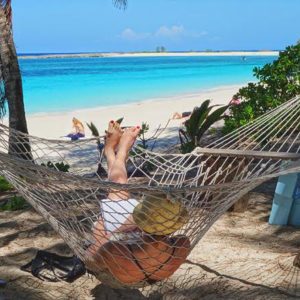 woman relaxing in hammock on beach