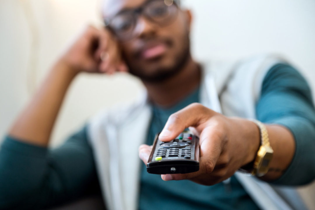 A man holds a remote control.